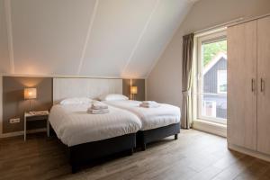 a bedroom with a bed and a large window at Villapark Ehzerburg in Almen