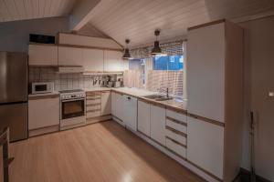 a large kitchen with white cabinets and a window at Fagertoppen 12B in Trysil