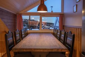 a dining room with a table and chairs and a window at Fagertoppen 12B in Trysil