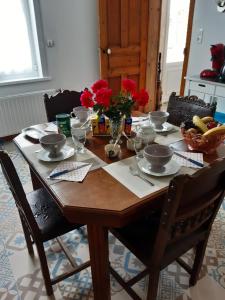 uma mesa de madeira com pratos, tigelas e flores em AU COEUR DE L'ENCLAVE em Moeuvres