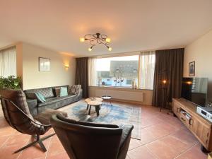 Una sala de estar con un sofá y un televisor. en Callantsoger Staete A107, en Callantsoog