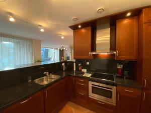 Una cocina con gabinetes de madera y un fregadero. en Callantsoger Staete A107, en Callantsoog