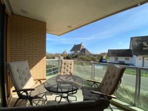 Un patio con dos sillas y una mesa en un balcón. en Callantsoger Staete A107, en Callantsoog