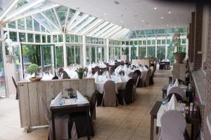 a restaurant with tables and chairs in a conservatory at Villapark Ehzerburg in Almen +19 photos