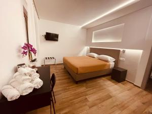 a bedroom with a bed and a table with towels at Affittacamere Residenza Montedoro in Norcia