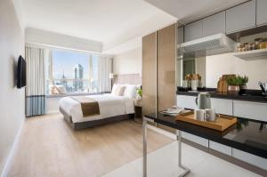 um quarto com uma cama e uma secretária com uma cozinha em Two MacDonnell Road em Hong Kong