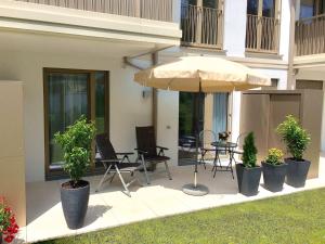 eine Terrasse mit einem Tisch, Stühlen und einem Sonnenschirm in der Unterkunft Ferienwohnung Schwan in Bad Reichenhall