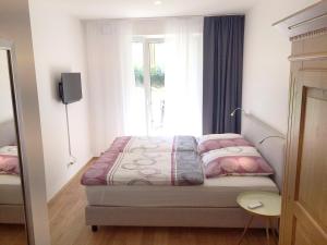 - une petite chambre avec un lit et une fenêtre dans l'établissement Ferienwohnung Schwan, à Bad Reichenhall