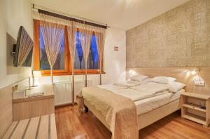 Un dormitorio con una cama grande y una ventana. en Oázis Apartmanok, en Mórahalom