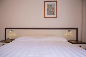 una camera da letto con un grande letto bianco con due tavoli di Hotel Fabricia a Portoferraio