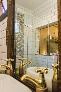 a bathroom with gold faucets and a sink at La Casa Nostra Rose Garden in Hillcrest