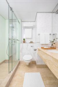 a bathroom with a toilet and a glass shower at Two MacDonnell Road in Hong Kong