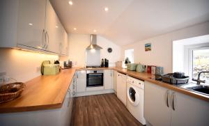 a kitchen with white cabinets and a sink at Tigh Beag Na Mara in Roag