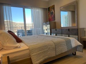 Un dormitorio con una cama grande y una ventana grande. en Marassi marina, en El Alamein