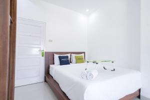 Tempat tidur dalam kamar di Urbanview Hotel Pondok Indah Pringsewu