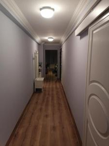 um corredor com paredes brancas e piso de madeira em House KA Naz em Canakkale