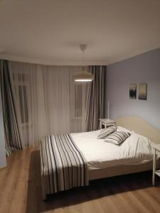 een slaapkamer met een groot bed met witte lakens bij House KA Naz in Canakkale