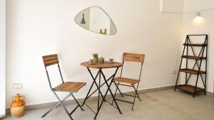tavolo e sedie in una stanza con specchio di Les Maisons Casetta del Vico by Rentbeat a Sannicola