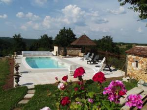 una piscina en un patio con flores en Gites des 3 Vallées en Salignac Eyvigues