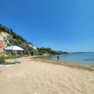 a man standing on a beach with an umbrella at Ecopark Tuzlata Екопарк Тузлата in Balchik