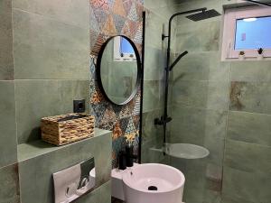 un baño con lavabo y espejo en Alexander Cozy Apartment FREE PRIVATE PARKING, en Mediaş 4 fotos más