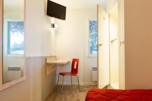 a room with a red chair and a small table at Premiere Classe Nantes Ouest - St Herblain in Saint-Herblain