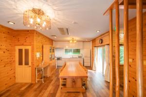 深山山荘 DENCHI في Uchiko: غرفة طعام مع طاولة ومطبخ