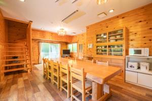 深山山荘 DENCHI في Uchiko: غرفة طعام مع طاولة وكراسي خشبية