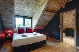1 dormitorio con 1 cama grande con almohadas rojas en Le Moulin Noir à 400m du circuit, en Francorchamps