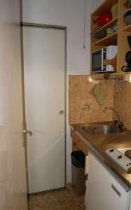 - une cuisine avec une porte blanche et un évier dans l'établissement Cauterets: studio 4 personnes idéalement situé., à Cauterets