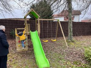 un garçon jouant sur un toboggan dans une aire de jeux dans l'établissement Belle Villa basque avec piscine et jardin de 3000m2, à Saint-Jean-de-Luz