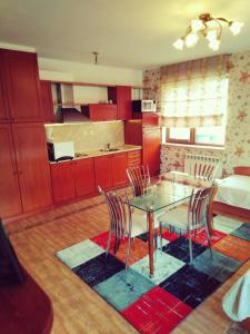 uma cozinha e sala de jantar com uma mesa de vidro e cadeiras em GD Apartament em Bansko