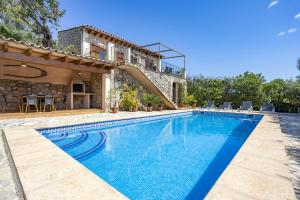 a villa with a swimming pool next to a house at Es Puchet in Búger