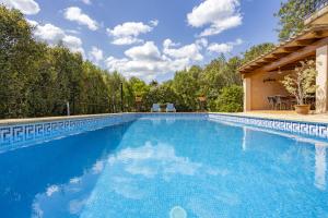 a large swimming pool with blue water at Es Puchet in Búger