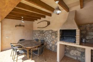 a dining room with a table and a fireplace at Es Puchet in Búger