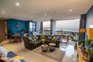 uma sala de estar com um sofá e vista para o oceano em Stay at The Point - Kaleidoscopic Caribbean Cruise em Durban