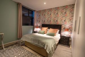 um quarto com uma cama com papel de parede floral em Stay at The Point - Kaleidoscopic Caribbean Cruise em Durban