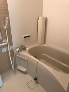 ein Badezimmer mit einer Badewanne und einem Telefon daneben in der Unterkunft cottage SOUL MATE in Ishigaki-jima