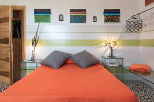 um quarto com uma grande cama laranja e 2 almofadas em Casa D'Artista - Le stanze della stupidità em Borgagne