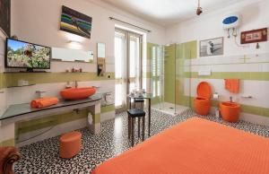 y baño con lavabo de color naranja y ducha. en Casa D'Artista - Le stanze della stupidità, en Borgagne