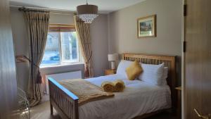 a bedroom with a bed with two shoes on it at 2 Bedroomed Ground Floor Apartment in Kenmare