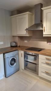 a kitchen with a washing machine and a washer at 2 Bedroomed Ground Floor Apartment in Kenmare