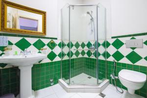baño verde y blanco con lavabo y ducha en Rustaveli Hotel, en Tiflis