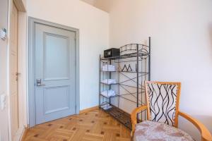 a room with a door and a chair and a shelf at Rustaveli Hotel in Tbilisi City