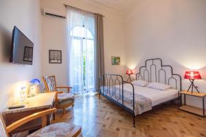 1 dormitorio con cama, mesa y escritorio en Rustaveli Hotel, en Tiflis