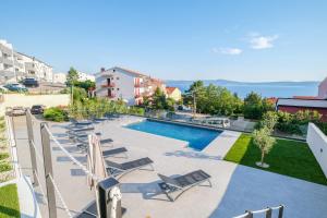 een zwembad met ligstoelen en een resort bij Apartment House Vista in Crikvenica