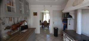 eine Küche mit einer Person, die in einem Zimmer steht in der Unterkunft Pavillon de Diane, Le Malesherbois 