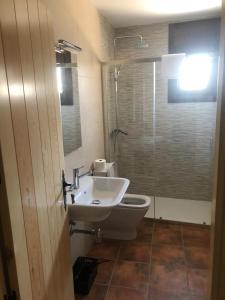 a bathroom with a toilet and a sink and a shower at Casa Rural El Corral del Tío Santiago in Mazaleón