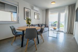 een woonkamer met een tafel en stoelen en een bank bij Apartment House Vista in Crikvenica