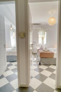 a bedroom with two beds and a checkered floor at Stylish, Cozy 2-BDR Flat in Andros Town in Andros